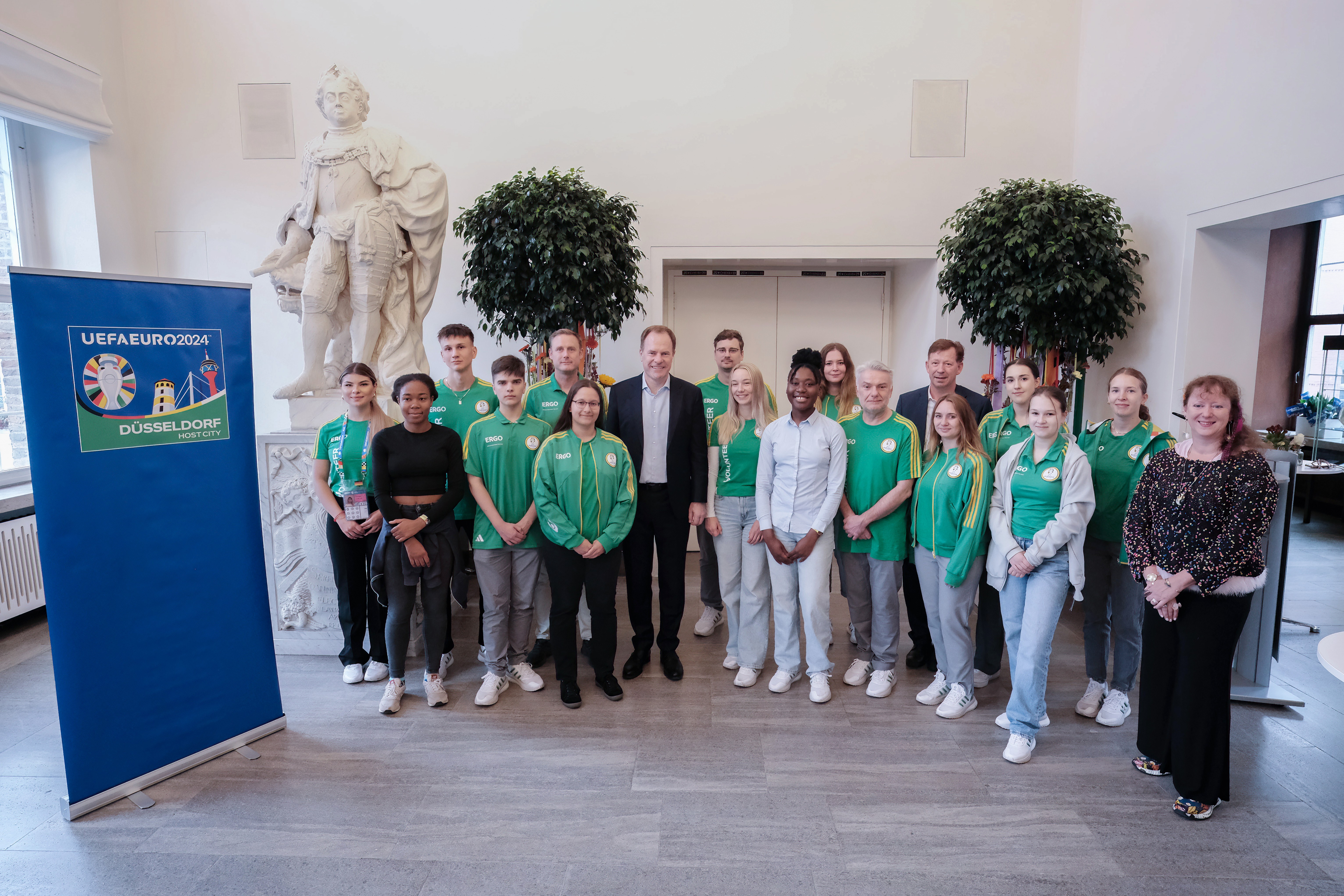 OB Dr. Stephan Keller mit den Volunteers aus den Partnerstädten und den städtischen Auszubildenden, die als Lead-Volunteers im Einsatz sind, sowie mit Staatssekretärin Andrea Milz (r.). Foto: Gstettenbauer