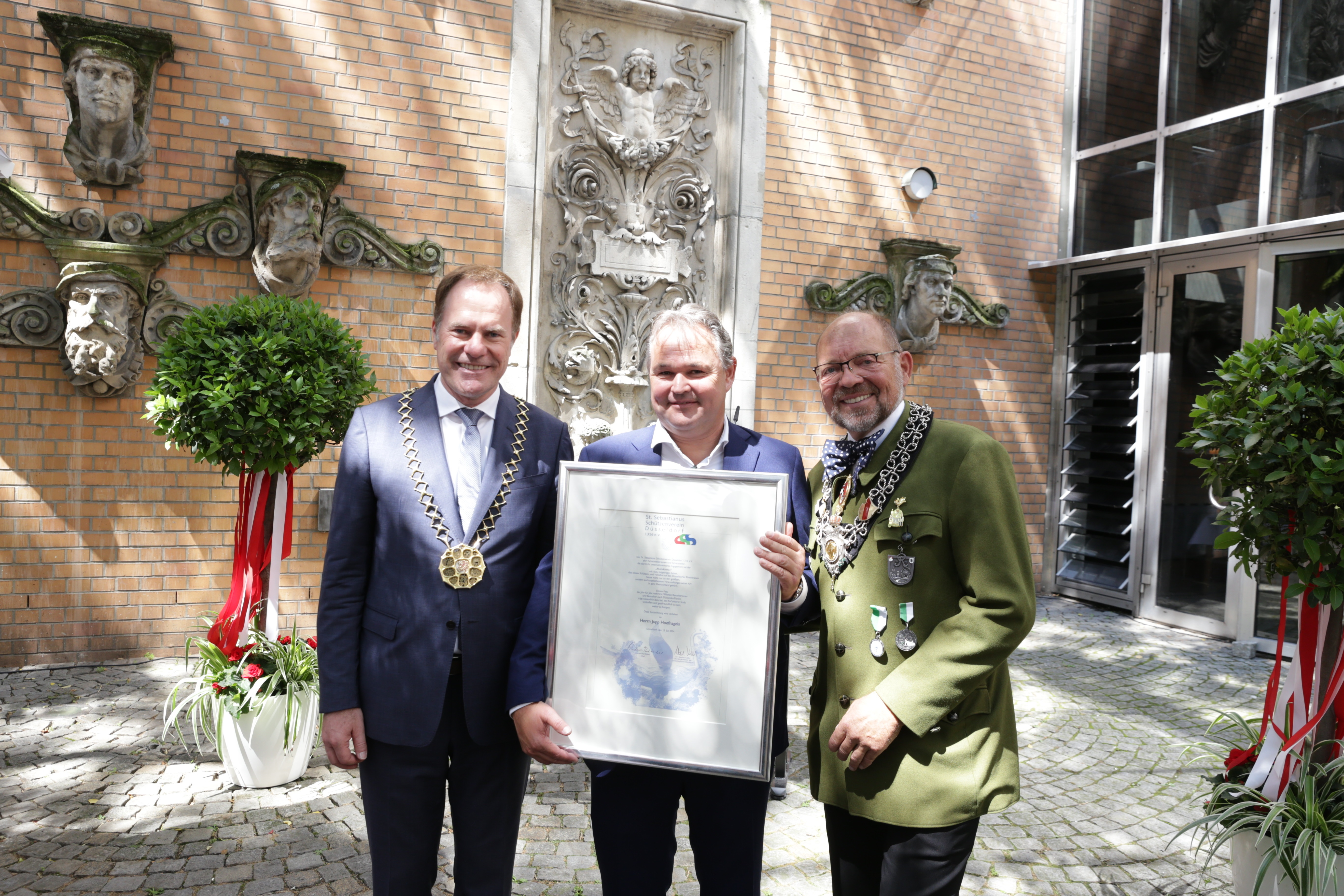 OB Dr. Stephan Keller (li.) hat am Montag, 15. Juli, im Rahmen eines Empfangs im Innenhof des Rathauses gemeinsam mit Schützenchef Andreas-Paul Stieber (r.) den Schausteller Joseph Hoefnagels geehrt, Fotos: Lammert.