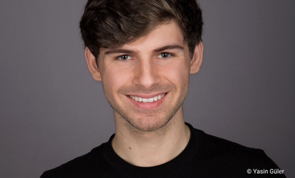 Porträtfoto eines jungen Mannes, der in die Kamera lächelt