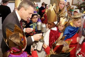 Oberbürgermeister Thomas Geisel wirft seinen Obolus in die Sammeldosen der Sternsinger