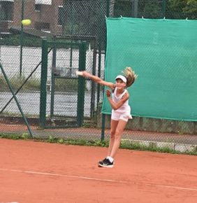 eine junge Tennisspielerin beim Aufschlag