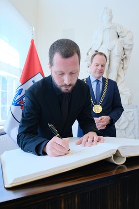 Mstyslav Chernov trug sich beim Empfang im Jan-Wellem-Saal des Rathauses ins Goldene Buch der Stadt ein. Foto: Michael Gstettenbauer