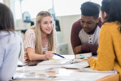 Weibliche und männliche Jugendliche sitzen zusammen am Tisch, Foto: iStock, SDI Productions