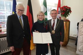 Oberbürgermeister Thomas Geisel hat im Rahmen eines Empfangs im Rathaus Brita Siebke-Holzapfel das Verdienstkreuz am Bande überreicht. Mit dabei ihr Ehemann, Harald Siebke (l.). Foto: David Young