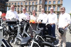 Foto von Oberbürgermeister Dr. Stephan Keller, Dr. Sebastian Rapsch, ERGO, Signe Storgaard Sørensen, Donkey Republic, Dr. Oliver Horn, ERGO, Christian Molt, ERGO, und CMD-Geschäftsführer Rolf Neumann die als Gruppe hinter ein paar Düsselbikes stehen.
