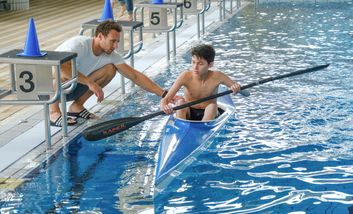 Trainer erklärt Kind das Kanufahren