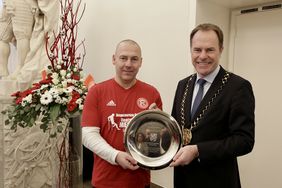 Als Erinnerung an den Rathaus-Empfang überreichte Oberbürgermeister Dr. Stephan Keller einen gravierten Stahlteller an Fortunas Sportlichen Leiter Stefan Felix, der zudem Inklusionsbeauftragter des Vereins ist. Foto: Ingo Lammert