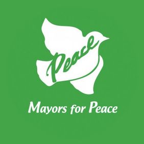 Das Logo von "Mayors for Peace", eine weiße Taube auf grünem Grund, auf der "Peace" steht