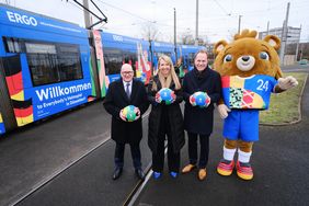 Dr. Markus Rieß (ERGO, l.), Annette Grabbe (Rheinbahn, 2.v.l.), Oberbürgermeister Dr. Stephan Keller (3.v.l.) und Maskottchen Albärt stellen die deutsche Willkommensbahn vor. Foto: Michael Gstettenbauer