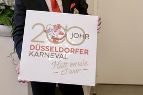 Das neue Jubiläumslogo der Session 2024/2025: Es zeigt den Hoppeditz mit einem sprudelnden Sektglas in der Hand inmitten der als Endlosschleife designten Zahl 200 und das Sessionsmotto.