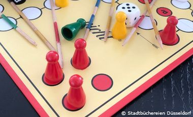 Foto von Brettpiel mit Spielfiguren, Würfeln und Mikadostäbchen