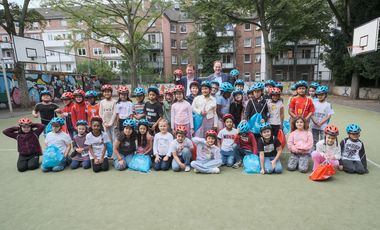 Oberbürgermeister Dr. Stephan Keller (r.) und Stadtdirektor Burkhard Hintzsche mit den Schülerinnen und Schülern des Familiengrundschulzentrums Sonnenstraße und ihren neuen "DüsselHelmen". Fotos: Michael Gstettenbauer