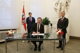 Der neu gewählte Oberbürgermeister Dr. Stephan Keller unterzeichnet die Annahmeerklärung der Wahl im Beisein von Oberbürgermeister Thomas Geisel (r.) und Wahlleiter Christian Zaum. Foto: David Young