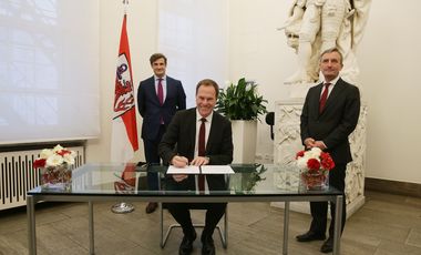 Der neu gewählte Oberbürgermeister Dr. Stephan Keller unterzeichnet die Annahmeerklärung der Wahl im Beisein von Oberbürgermeister Thomas Geisel (r.) und Wahlleiter Christian Zaum. Foto: David Young