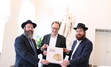 Anlässlich des Pessach-Festes überreichte der Rabbiner Chaim Barkahn (l.) eine handgemachte Mazzah Schemurah, einen Laib ungesäuertes Brot, an Oberbürgermeister Dr. Stephan Keller. Begleitet wurde er von Rabbiner Levi Hefer (r.), Foto: Lammert