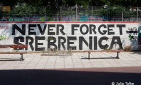 Foto mit Text auf einer öffentlichen Wand: Never forget Srebrenica