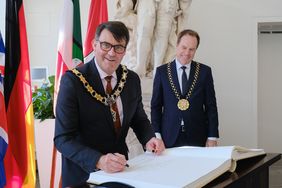 David Stevens (l.), Bürgermeister von Düsseldorfs Partnerstadt Reading, trägt sich beim Empfang ins Goldene Buch der Landeshauptstadt ein. Foto: Michael Gstettenbauer