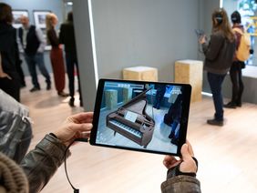 Augmented Reality lässt Claras Flügel im Ausstellungsraum erscheinen 