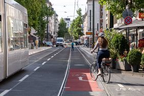 Foto von Radfahrerin, die das Velogleis überfährt.