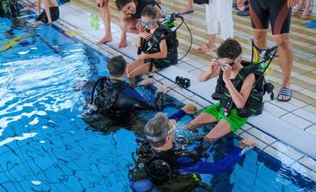 Trainer mit zwei Kindern beim Tauchen