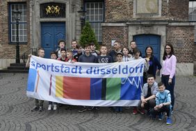 Gruppenbild der russischen Jugendhandballmannschaft auf dem Marktplatz, mit einem "sportstadt düsseldorf"-Banner