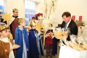 Stadtdirektor Burkhard Hintzsche bedankt sich mit Weckmännern für das Engagement der Sternsinger. Foto: Lammert