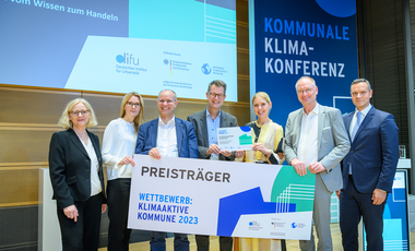 Katja Riese (2.v.l.), Stefan Wenzel (3.v.l.), Stefan Ferber (M.) und Theresa Winkels (3.v.r.) von der Landeshauptstadt mit Cornelia Rösler (l.) vom Difu, Moderator und Diplom-Meteorologe Sven Plöger (2.v.r.) und Dr. Sven Reinhardt vom BMWK © Peter Himsel/Difu 