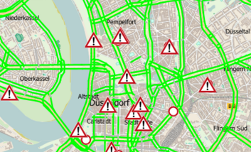 Schmuckbild: Symbolische Verkehrskarte von Düsseldorf mit Warnzeichen und grün markierten Straßen.
