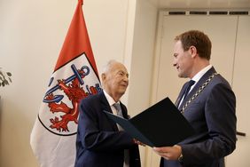 Oberbürgermeister Dr. Stephan Keller (r.) überreichte Dan Georg Bronner die Verdienstplakette der Landeshauptstadt Düsseldorf. Foto: Landeshauptstadt Düsseldorf/Ingo Lammert