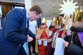 OB Dr. Stephan Keller füllt die Sammelbüchsen der Sternsingerinnen und Sternsinger, Foto: Gstettenbauer.