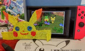 Foto mit Spielkonsole und Pokemonfiguren zweidimensional und in 3D.