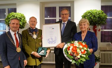 Oberbürgermeister Thomas Geisel, Schützenchef Lothar Inden, der geehrte Schausteller Oscar Bruch jr. mit Urkunde und seine Mutter Inge (v. l.)