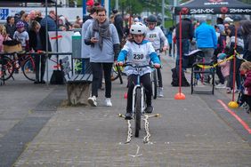 Foto von Kind auf inem Fahrrad das durch einen Hindernisparkour fährt