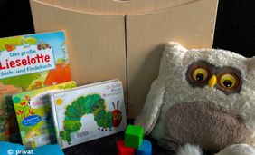 Foto mit Kamishibai Theater, Bilderbüchern und Kuscheltieren