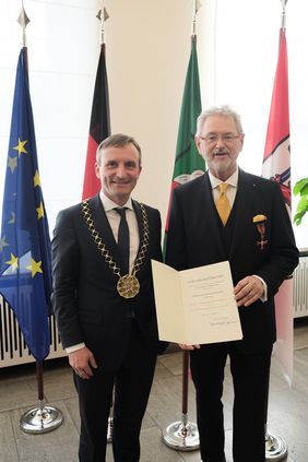 Oberbürgermeister Thomas Geisel verleiht das Bundesverdienstkreuz an Christoph Nachtigäller. Foto: Gstettenbauer