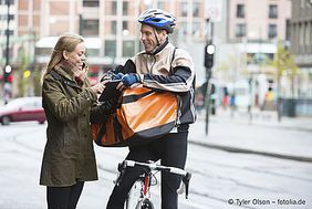 Fahrradkurier bei der Übergabe seiner Sendung 