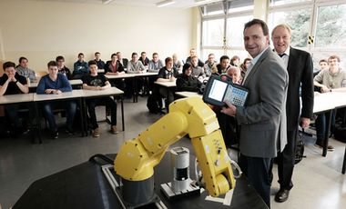 Schüler eines Berufskollegs bei der Ausbildung an einem FANUC-Industrieroboter.