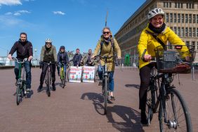 Gruppenbild von Radfahrern mit Stadtradeln-Plakat zum Auftakt am Rheinufer