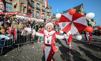 Ein Clown steht vor Zuschauern beim Rosenmontagszug