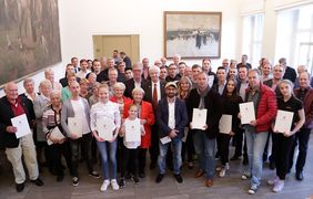 Bürgermeister Günter Karen-Jungen (Mitte) und Peter Schwabe, Präsident des Stadtsportbundes, mit Sportlern, die für ihre Erfolge 2016 geehrt wurden; Foto: Lammert