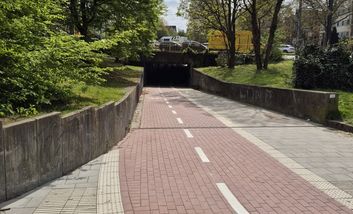 Foto von rot gepflasterten Zweirichtungsradweg, der von der Gutenbergstraße durch die Unterführung an die Limburgstraße anschließt.