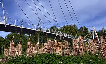 Frisch gepflanzte junge Bäume in der Nähe einer Fußgängerbrücke, die über die Garonne auf die Île du Ramier in Toulouse führt.