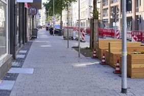 Die Gehwege entlang der Friedrichstraße haben graue Betonpflastersteine, kleinere antharzitfarbene Betonsteine kennzeichnen die sogenannten multifunktionalen Bereiche u.a. können dort Außengastronomie stattfinden oder Ladezonen und Parkplätze eingerichtet werden. © Landeshauptstadt Düsseldorf/ Claus Langer