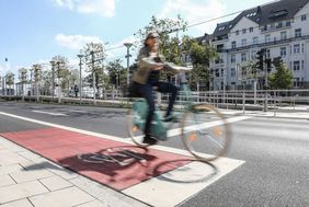 Radfahrerin auf einem rot markierten FAhrradschutzstreifen.