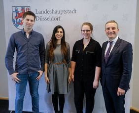 Oberbürgermeister Thomas Geisel mit den Siegern des Wettbewerbs (von links nach rechts): Jan Martin Müller (1. Platz), Azin Oladi (3. Platz) und Carina Noll (2. Platz).