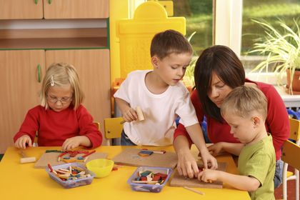 mehrere Kinder sitzen am Tisch und spielen, ©matka_Wariatka, iStock